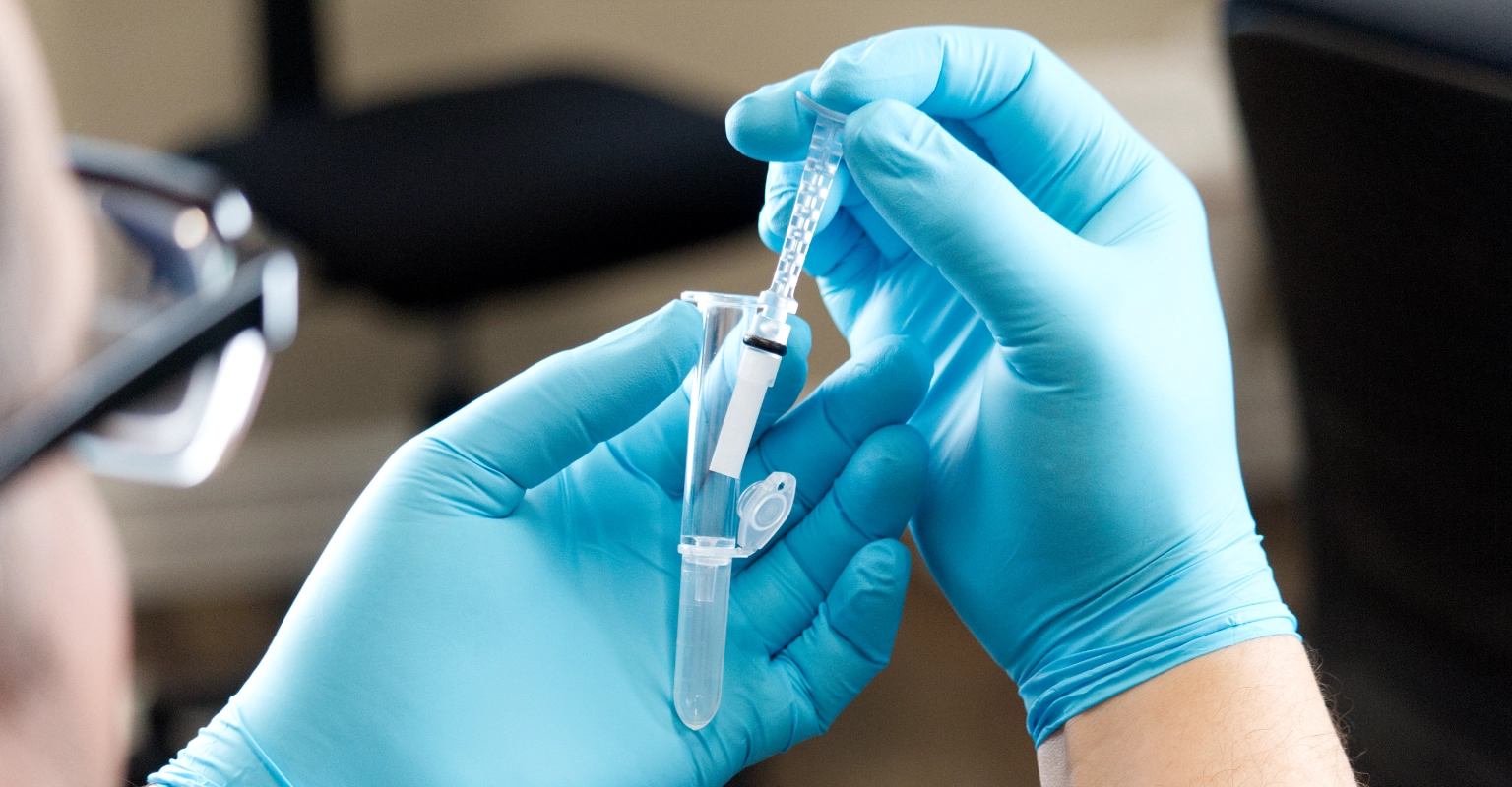 Gloved hands handling OraConfirm™ for laboratory transport